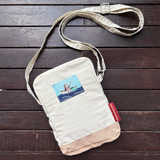 Otterwise Crossbody Bag front with woven logo of otter on the riverboat