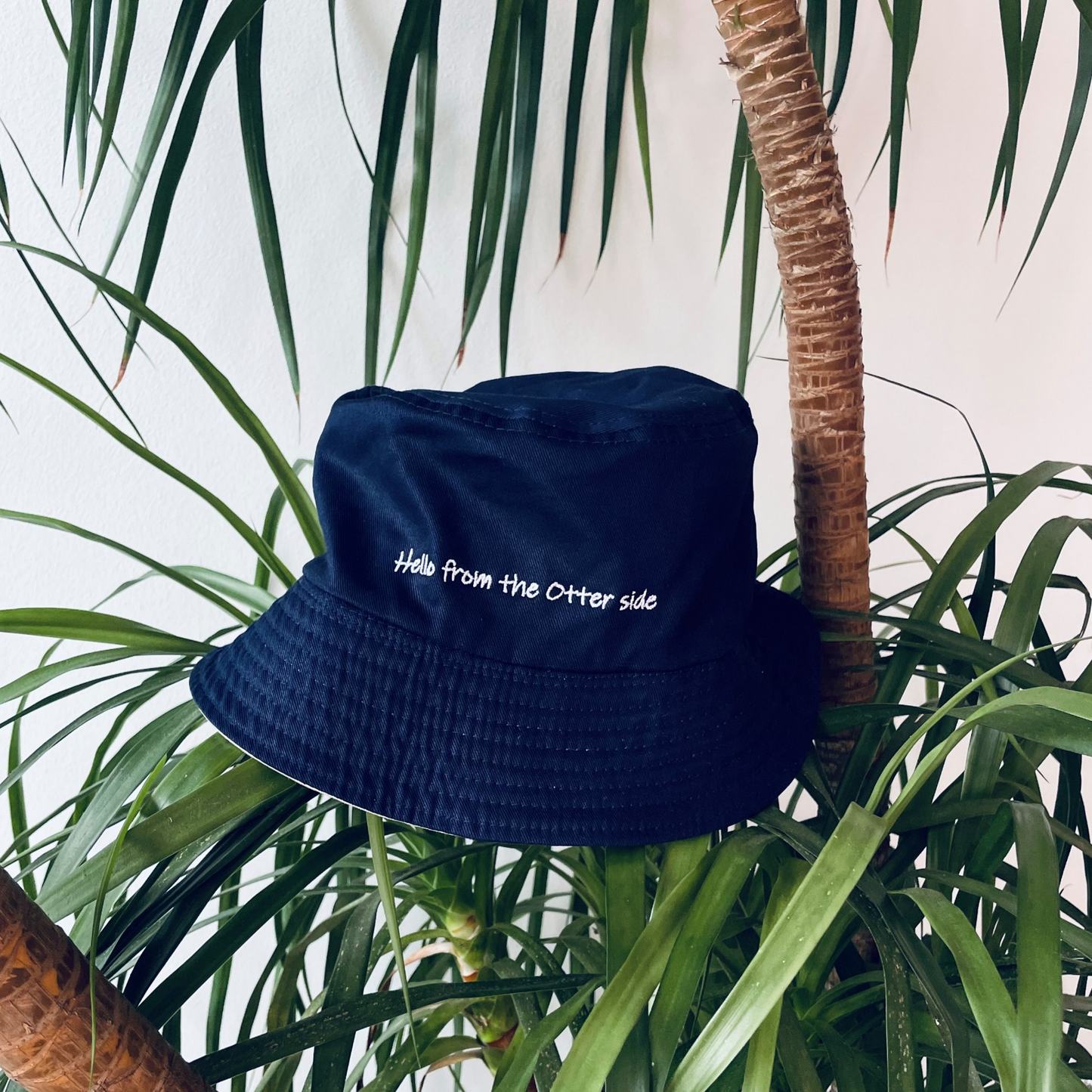 Otterwise Reversible Bucket Hat Back with "Hello from the otter side" embroidery.