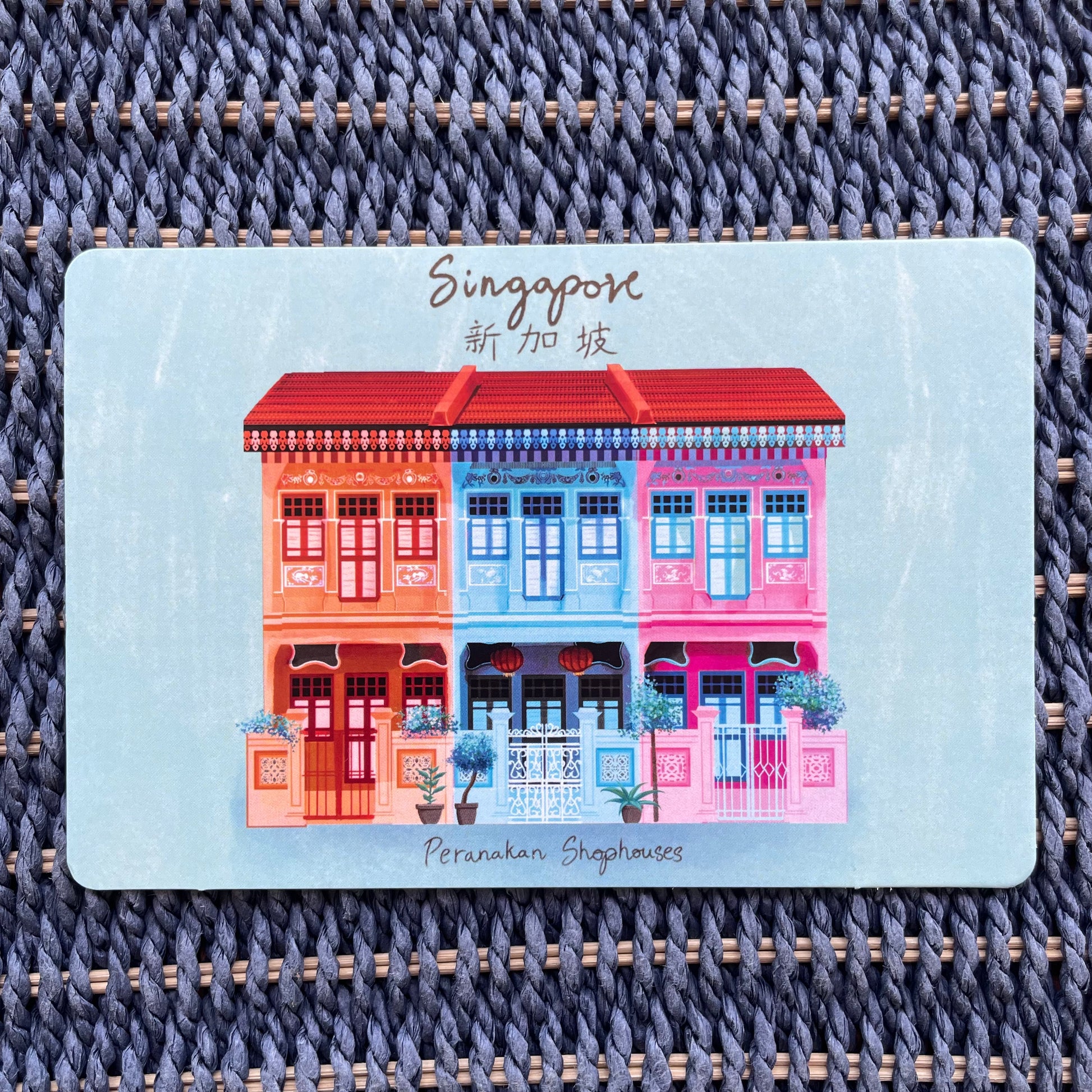 A colorful postcard featuring hand-drawn Peranakan shophouses in Singapore
