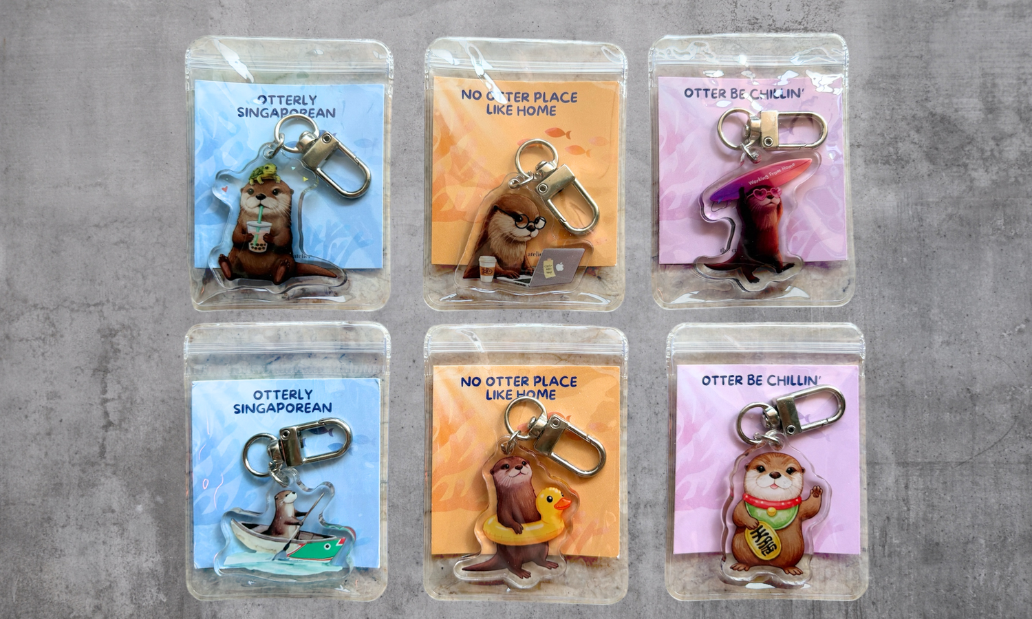 Set of six otter-themed keychains in packaging